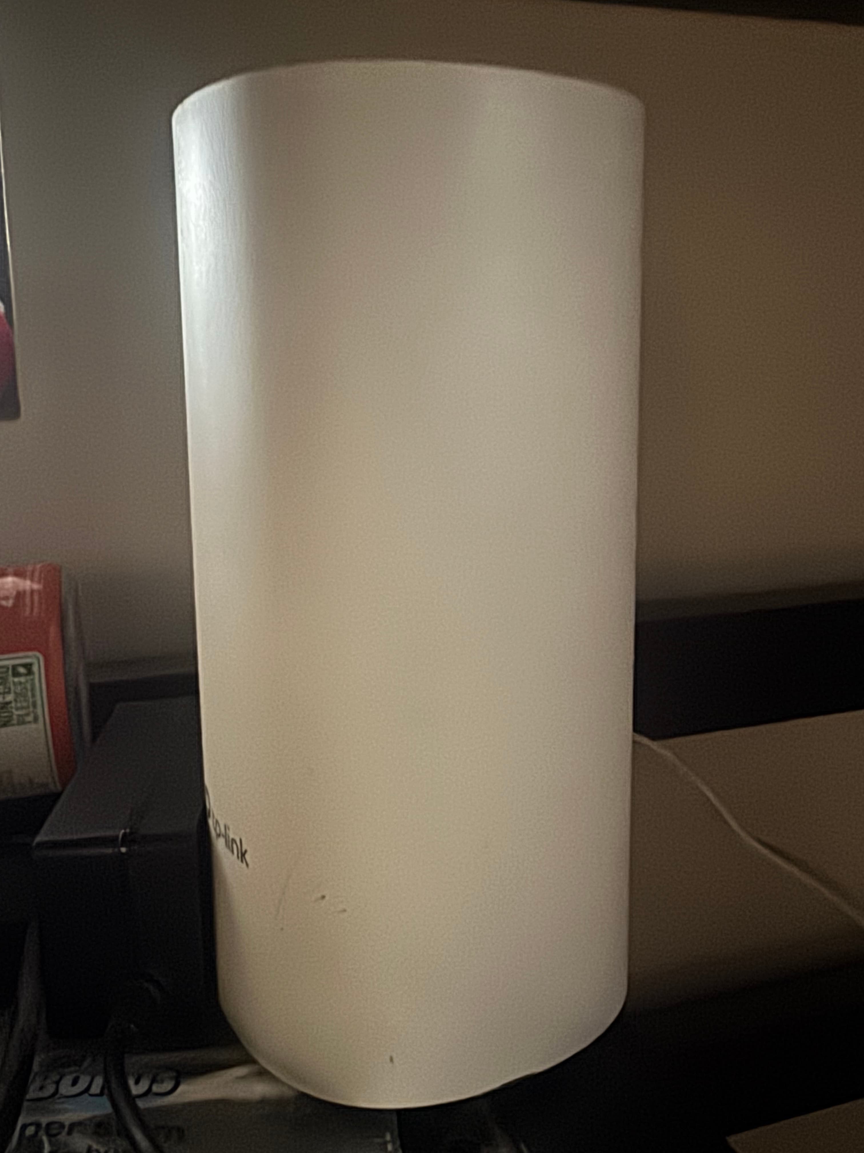 White cylindrical tp-link repeater standing upright